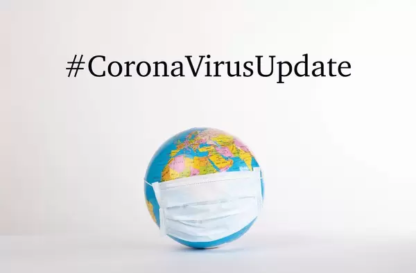 Globe with medical mask and #CoronaVirusUpdate text on white background