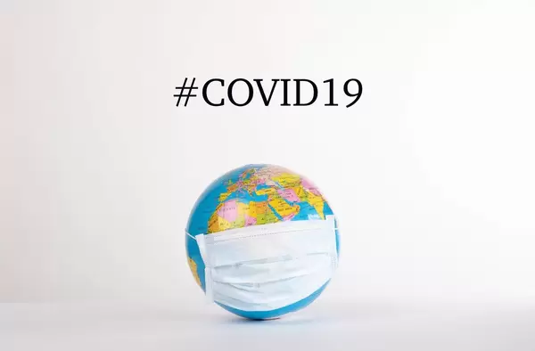 Globe with medical mask and #COVID19 text on white background.jpg