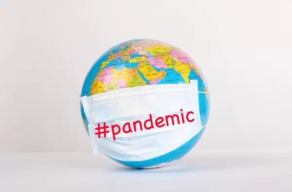 Globe with medical mask on white background with #pandemic text
