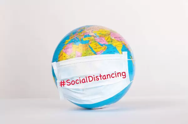 Globe with medical mask on white background with #SocialDistancing text