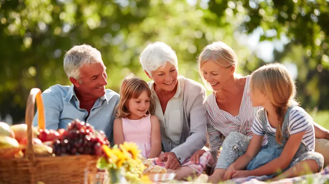 Glückliche Familie beim Picknick im Garten