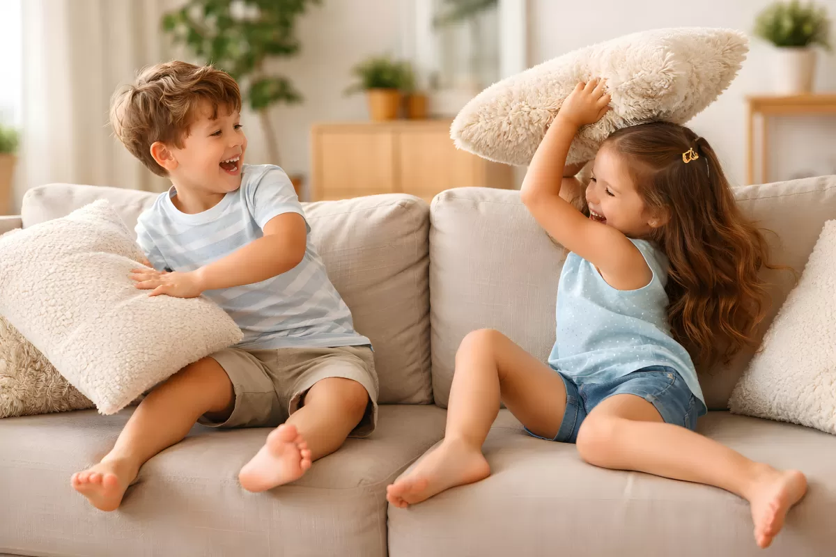 Glückliche Geschwister spielen auf der Couch