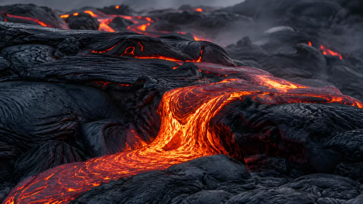 Glühende Lava fließt über erkaltete Basaltfelsen