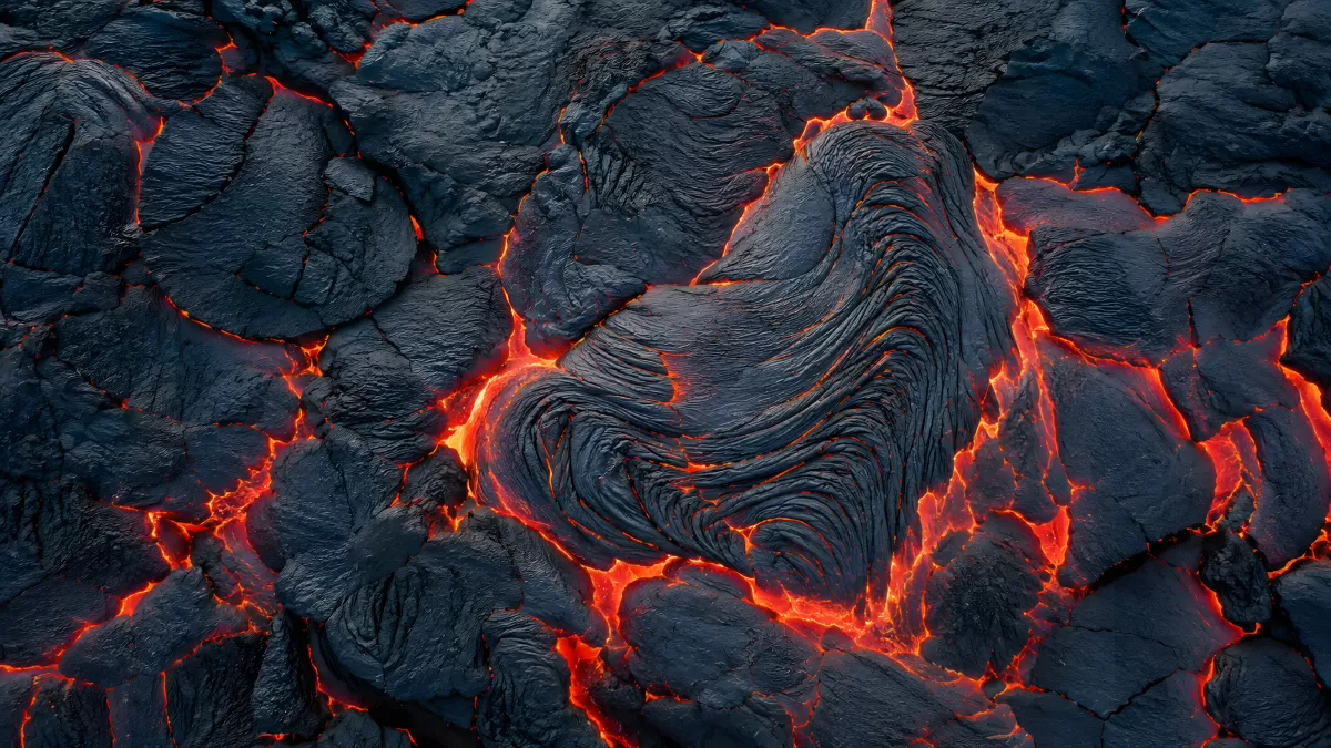 Glühende Risse in erkaltender Lava von oben