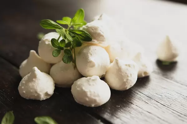 Glutenfreie Kokosnuss-Baiser-Törtchen, gestapelt auf einem braunen Holztisch