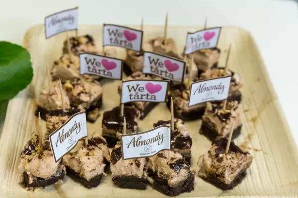 Glutenfreie Mandelgebäck-Häppchen des Almondy Toblerone Kuchen, mit "We love tårta" Fähnchen