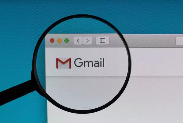 Gmail Logo und Schriftzug, vergrößert durch ein Lupenglas dargestellt