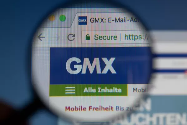 GMX-Logo am PC-Monitor, durch eine Lupe fotografiert