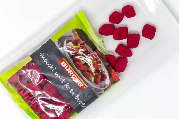 Gnocchi mit roter Bete fallen aus der Verpackung auf einen Teller