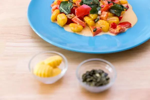 Gnocchi with pumpkin seeds in pepper sauce with gnocchi and pumpkin seeds in small glass bowls