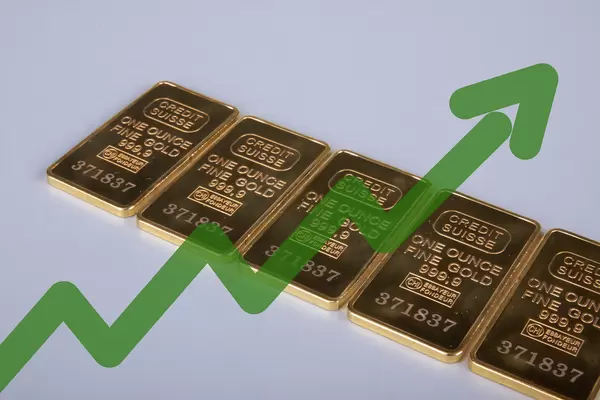 Gold bars with green up chart on grey background