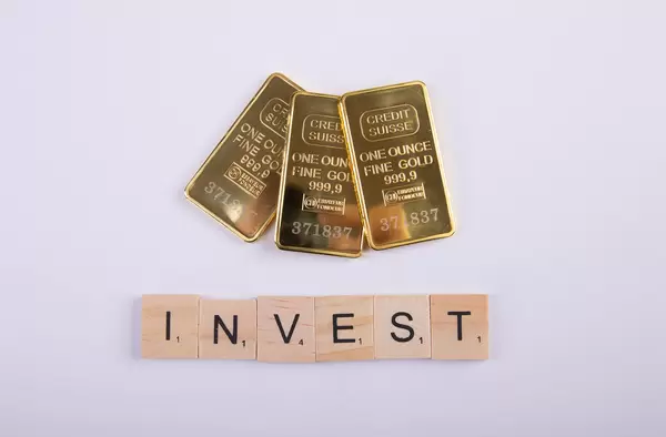 Gold bricks with Invest text on wooden blocks