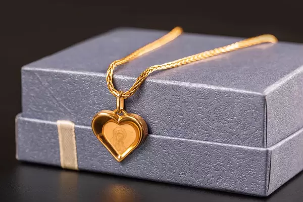 Gold chain and pendant on purple gift box