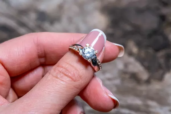 Gold ring with stones in the hands of the girl