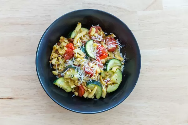 Goldbraun gebratene Spätzle mit getrockneten Tomaten und Zucchini. Draufsicht