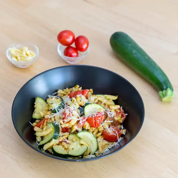Goldbraun gebratene Spätzle mit getrockneten Tomaten und Zucchini inklusive Zutaten. Quadratische Aufnahme