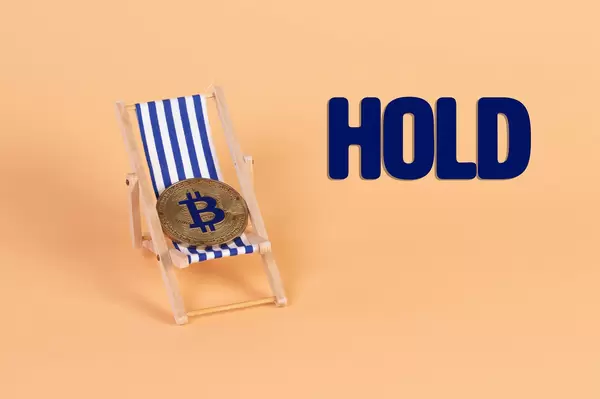 Golden Bitcoin coin lying in a deck chair with Hold text