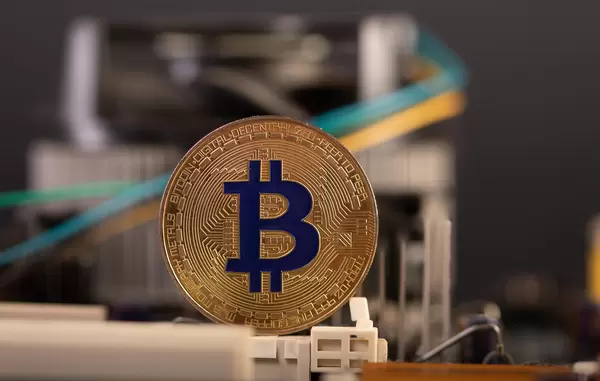 Golden Bitcoin coin on computer parts background
