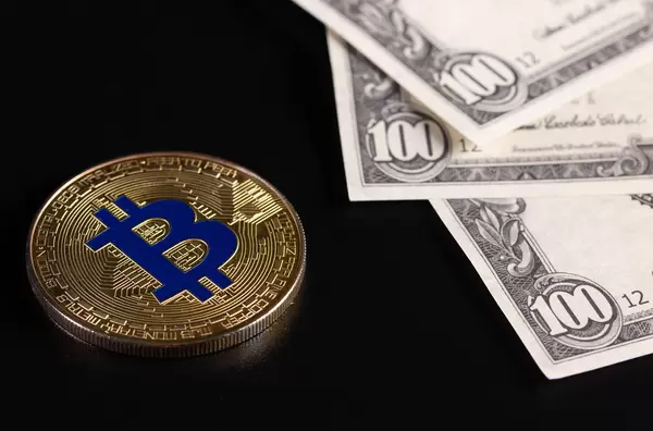 Golden Bitcoin coin with US dollar banknotes