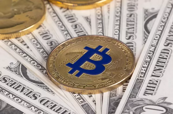 Golden Bitcoin on dollars banknotes