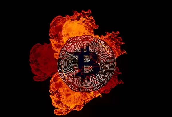 Golden Bitcoin on fire over black background