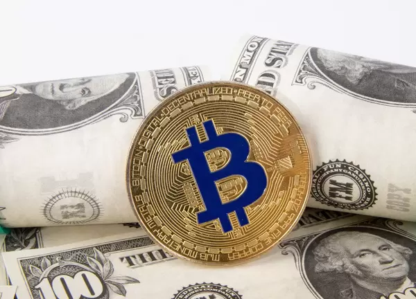 Golden Bitcoin with dollar banknotes