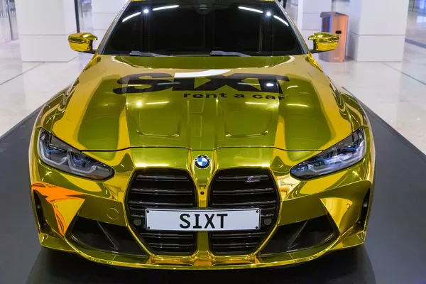 Golden car with logo of car rental company Sixt on display at the new Berlin airport BER. Front view