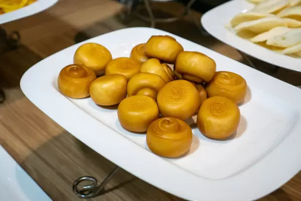 Golden Deep Fried Mantou and Shrimp Chips on Large White Plates at a Catering Buffet in an Asian Restaurant