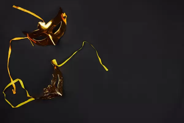 Golden Mardi Gras masks on dark background