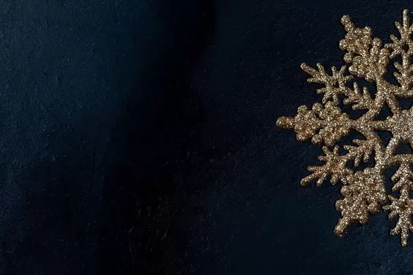 Golden snowflake on black background with free space (Flip 2019)