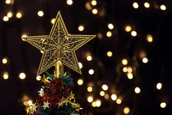 Golden star on top of a decorated Christmas tree on bokeh background (Flip 2019)
