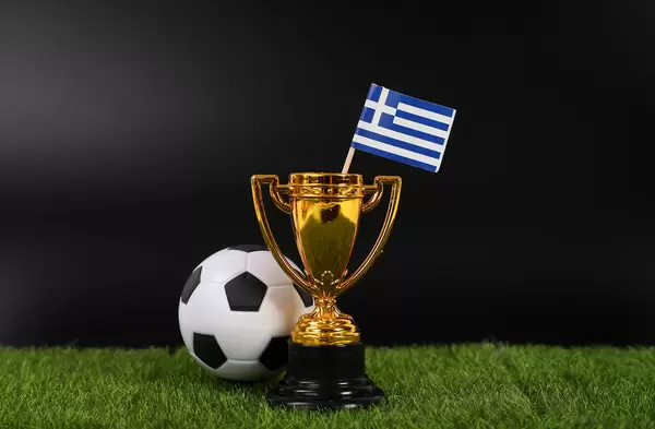 Golden trophy and football ball with flag of Greece