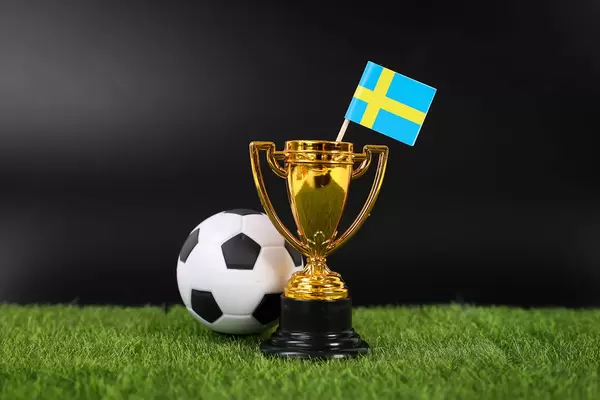 Golden trophy and football ball with flag of Sweden