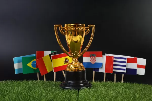 Golden trophy with national flags on grass