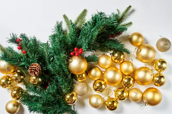 Golden Xmas baubles and evergreen tree branches from above