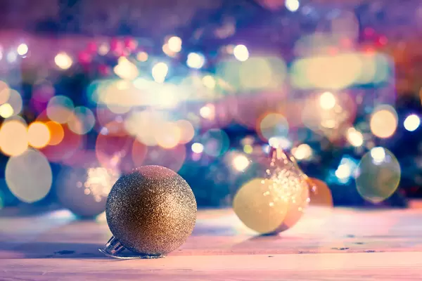 Golden Xmas decorative balls against Christmas background with bokeh lights