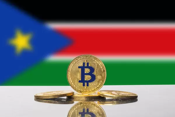 Goldene Bitcoin-Münze steht vor der Flagge des neu gegründeten Staates Südsudan