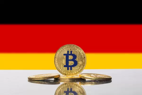 Goldene Bitcoins vor der Flagge der Bundesrepublik Deutschland, auch Schwarz-Rot-Gold genannt