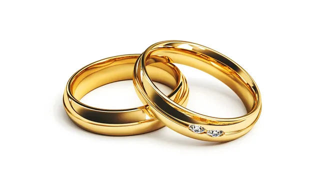 Goldene Eheringe mit Diamanten auf weißem Hintergrund