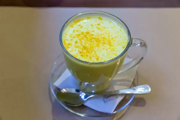 Goldene Milch mit Kurkuma, Ingwer und schwarzen Pfeffer gilt als gesunder Drink und wird im Petit Brot in Barcelona, Spanien, warm serviert