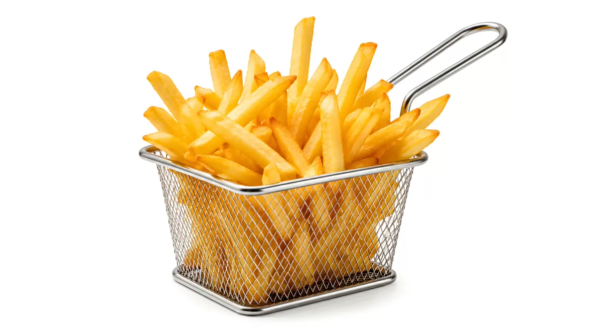 Goldene Pommes frites im Metallkörbchen serviert