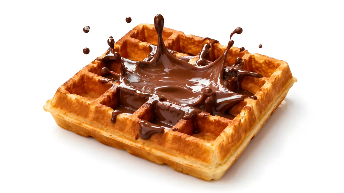 Goldene Waffel mit spritzender Schokoladensauce