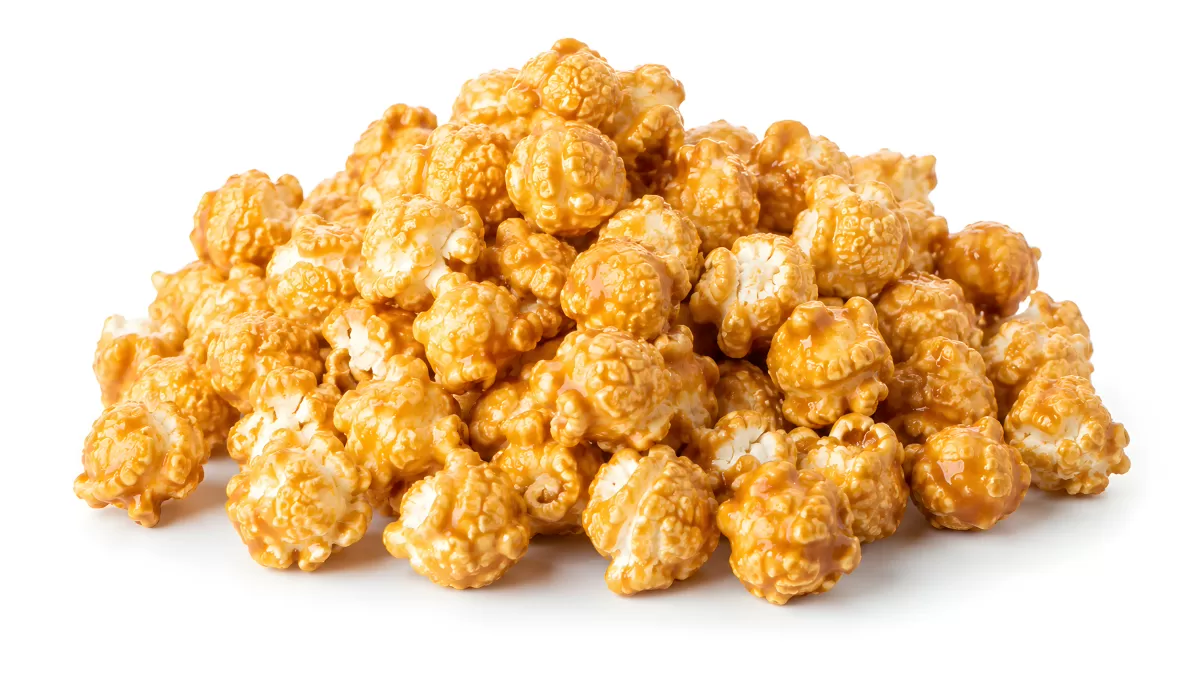 Goldener Karamellpopcorn-Haufen auf weißem Hintergrund