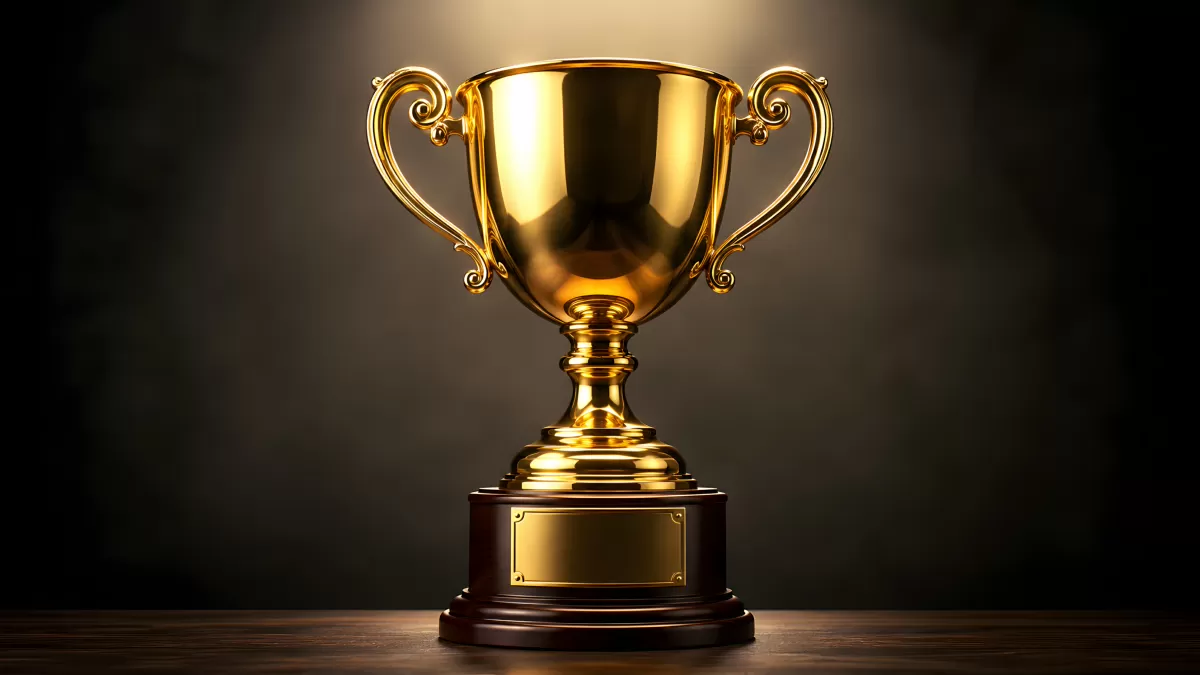 Goldener Pokal auf Holzsockel vor dunklem Hintergrund