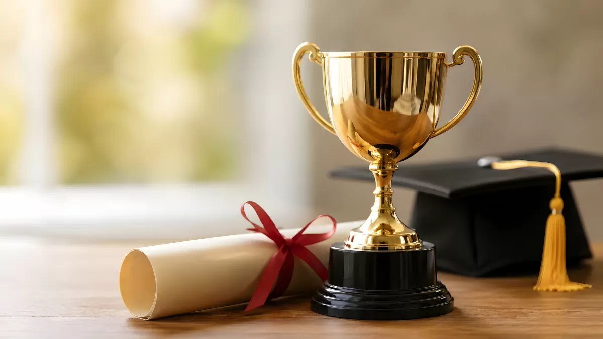 Goldener Pokal mit Diplom und Absolventenhut