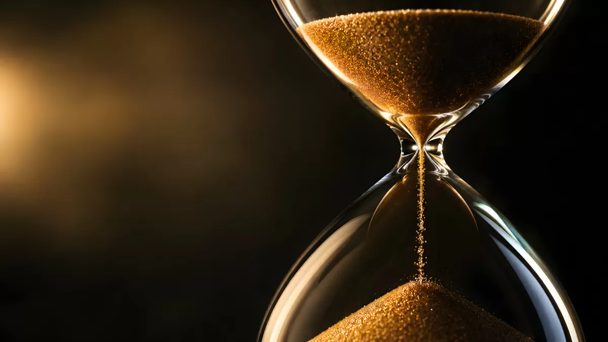 Goldener Sand rinnt durch eine gläserne Sanduhr