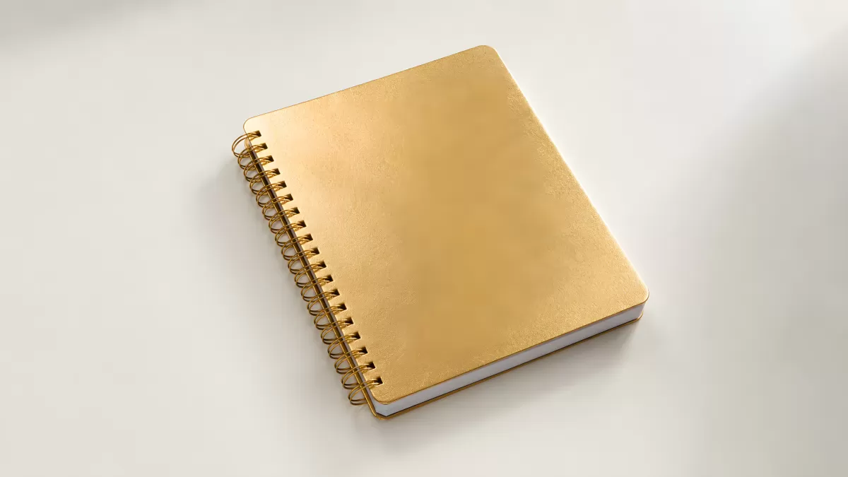 Goldenes Spiralnotizbuch auf hellem Untergrund