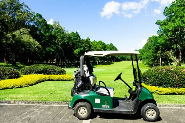 Golf car parked in front of a golf course