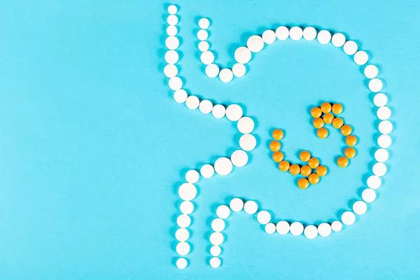Good digestion concept, human stomach is made of pills on a blue background