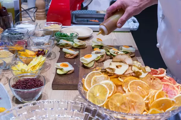 Gourmetkoch bei der Zubereitung von exotisch-belegten Brotscheiben